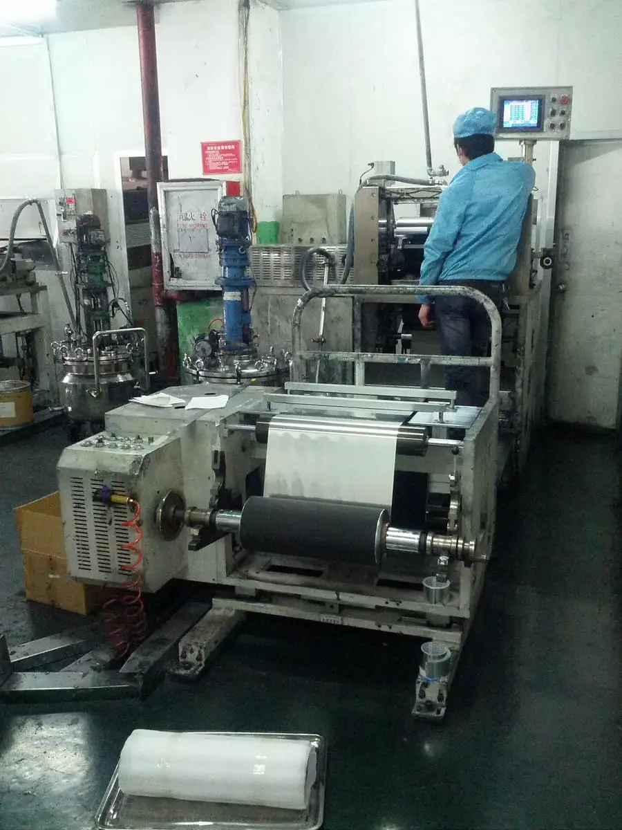 Large rolls of raw foil loaded into the coating machine.