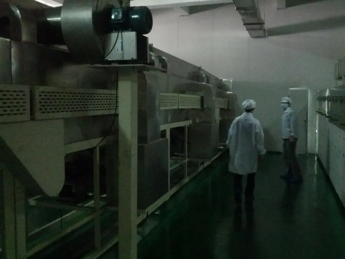 A ~20 m oven cures the slurry onto the terminal material.